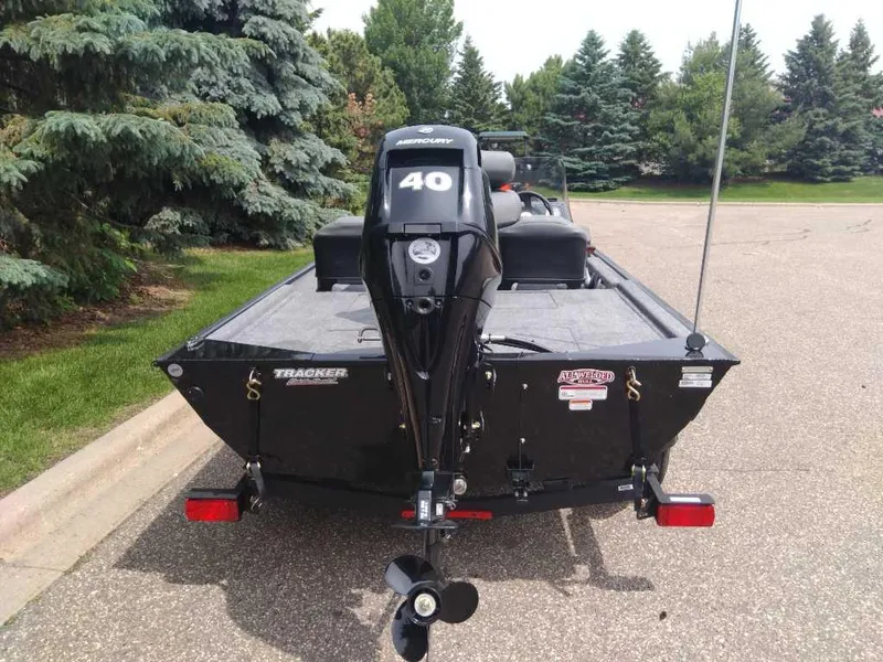 Slide: The Image of 2025 Tracker Bass Tracker Classic XL boat with Mercury 40 engine, parked on a road. - 2