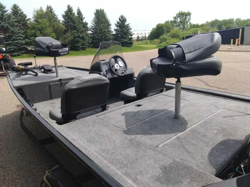 Slide: The Image of 2025 Tracker Bass Tracker Classic XL boat with seating and control panel, parked outdoors. - 6