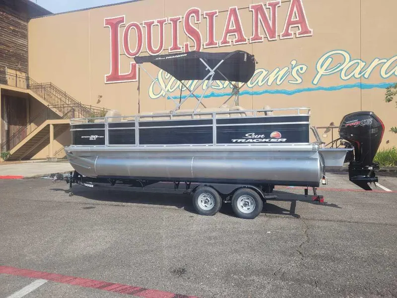 The Image of 2025 Sun Tracker SportFish 20 DLX pontoon boat parked outside Louisiana building. - 0