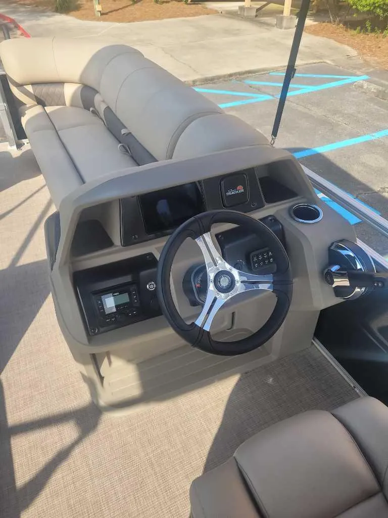 Slide: The Image of 2025 Sun Tracker SportFish 20 DLX boat interior with steering wheel and seating. - 7