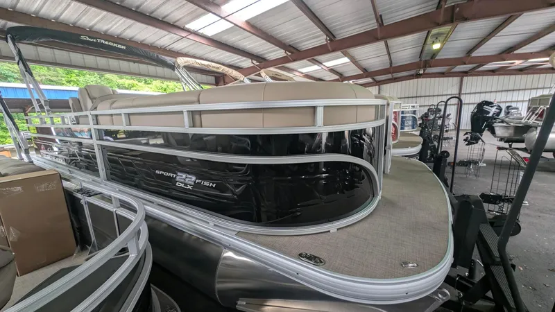 The Image of 2025 Sun Tracker SportFish 22 DLX pontoon boat in a covered storage area. - 0