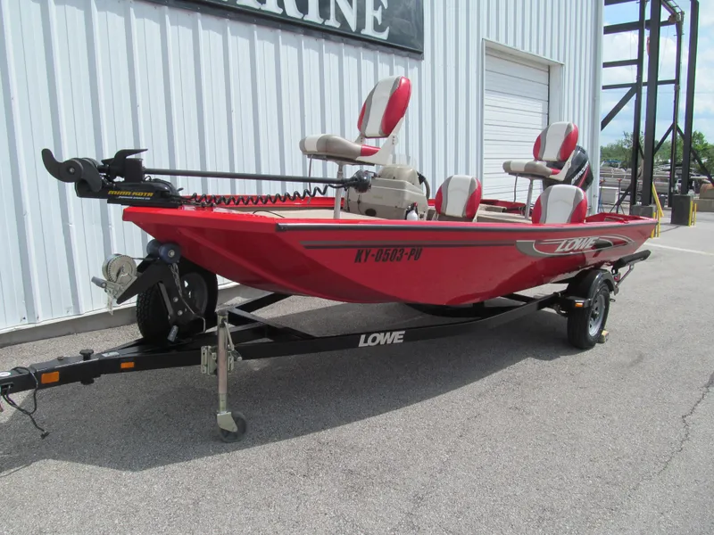 Slide: The Image of 2006 Lowe Stinger 160 boat in red on a trailer, parked outside a building. - 2