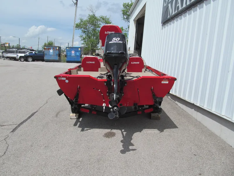 Slide: The Image of 2006 Lowe Stinger 160 boat with 50 HP Mercury engine, parked outside a building. - 4