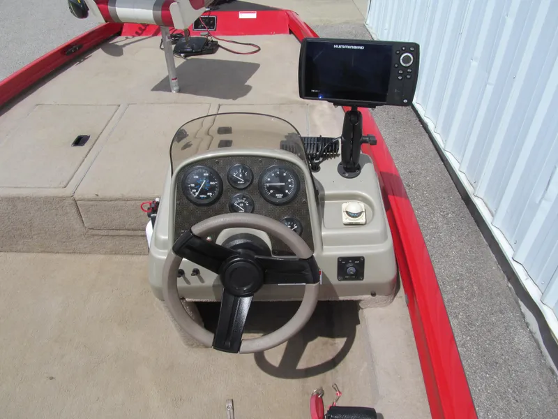 Slide: The Image of 2006 Lowe Stinger 160 boat dashboard with steering wheel and mounted fish finder. - 6