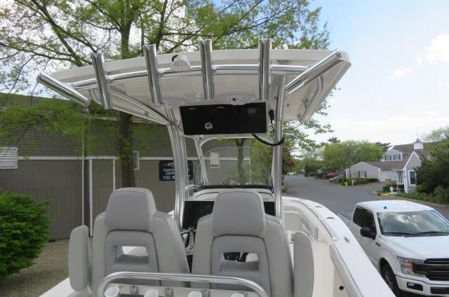 Slide: The Image of 2025 KenCraft 25 Offshore boat with T-top and dual seats, parked near residential area. - 22