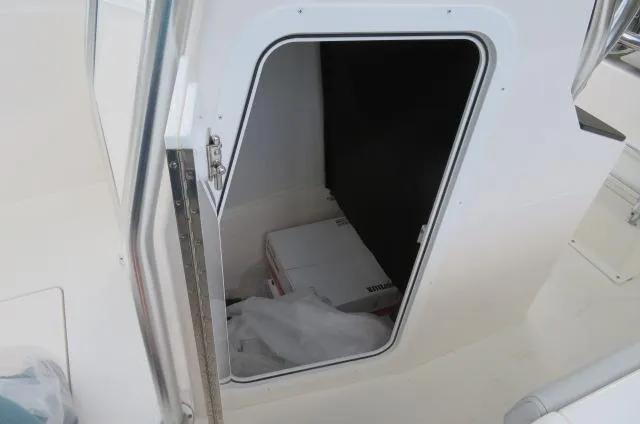 Slide: The Image of 2025 KenCraft 25 Offshore boat storage compartment with open door. - 46