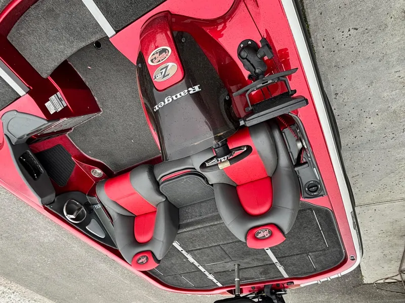 Slide: The Image of 2005 Ranger Z20 Comanche boat interior with red and black seating, steering console, and carpeted flooring. - 5