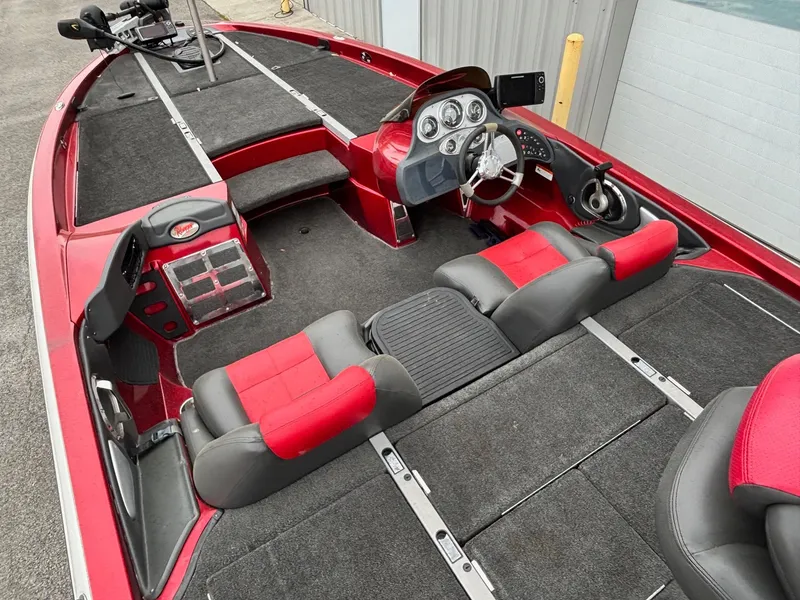 Slide: The Image of 2005 Ranger Z20 Comanche boat interior with red and gray seating, steering console, and spacious deck. - 8