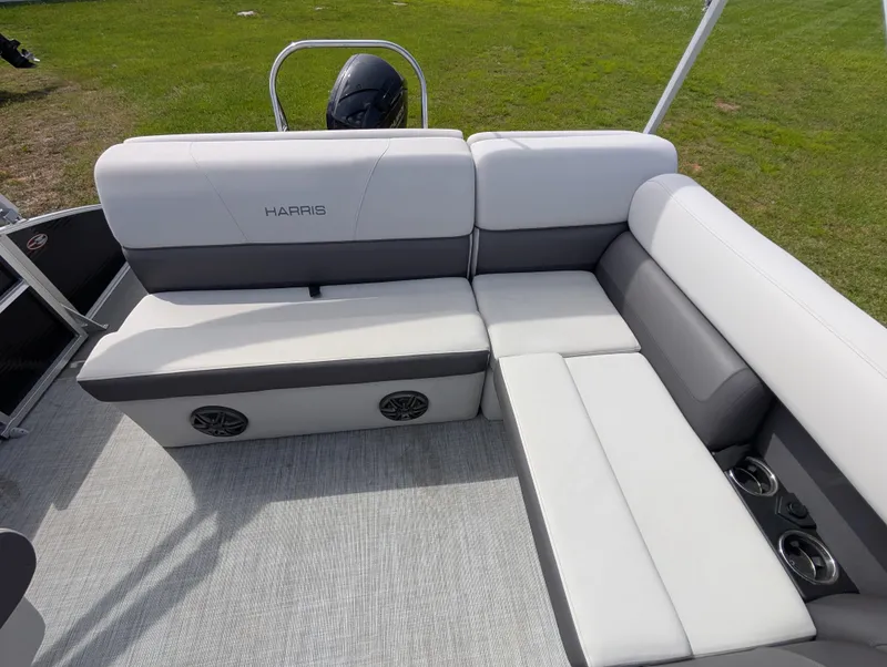Slide: The Image of 2022 Harris Cruiser 210 boat interior with white and gray seating, cup holders, and speakers. - 13