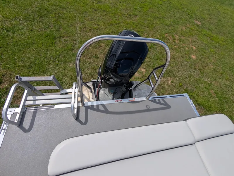 Slide: The Image of 2022 Harris Cruiser 210 boat with motor and ladder on grassy area. - 19