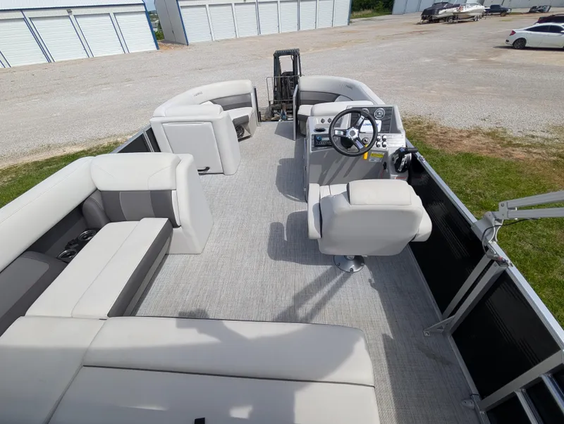 Slide: The Image of 2022 Harris Cruiser 210 pontoon boat interior with plush seating and steering console. - 21