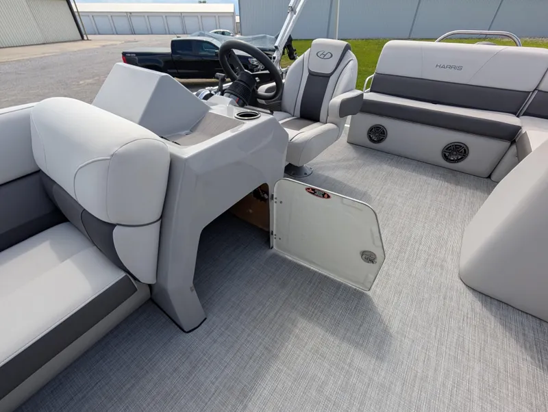 Slide: The Image of 2022 Harris Cruiser 210 boat interior with gray seating and open storage compartment. - 24