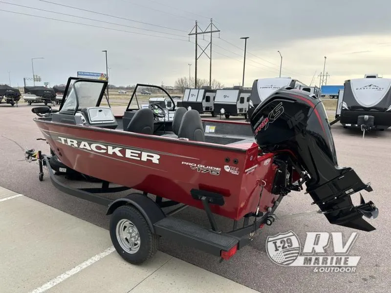 Slide: The Image of 2025 Tracker Pro Guide V-175 WT boat, red, parked outdoors near RVs. - 3