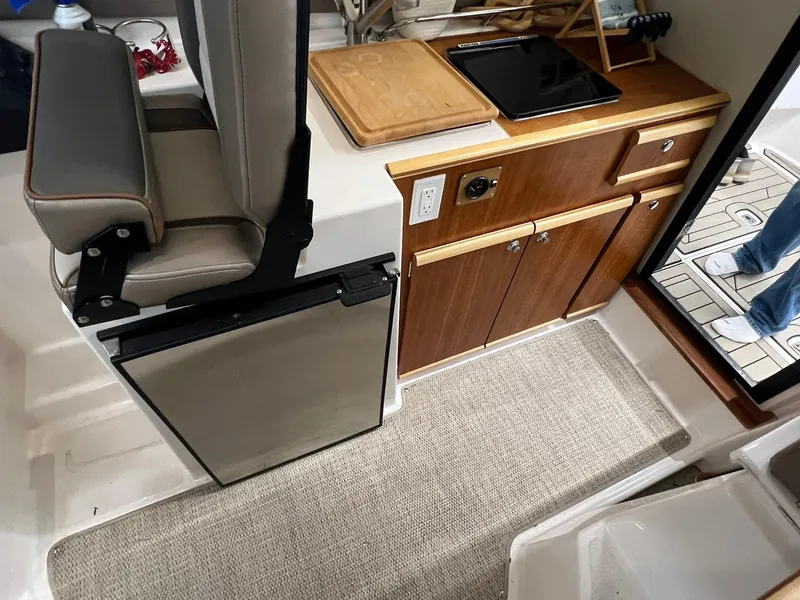Slide: The Image of 2022 Cutwater C-24 Coupe interior with kitchenette, seating, and modern amenities. - 12