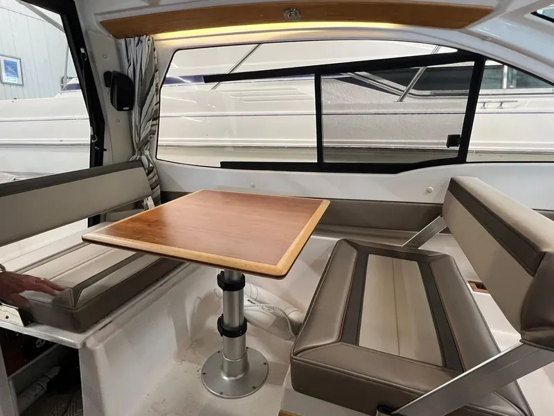 Slide: The Image of Interior of 2022 Cutwater C-24 Coupe with dining area and wooden table. - 17