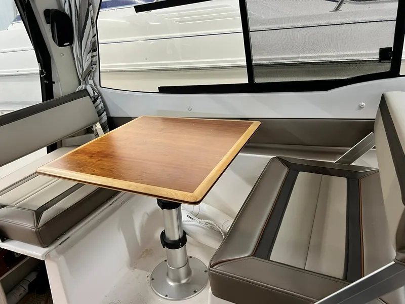 Slide: The Image of Interior of 2022 Cutwater C-24 Coupe with wooden table and cushioned seating. - 19