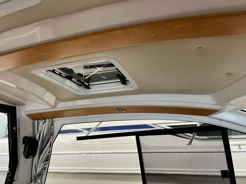 Slide: The Image of 2022 Cutwater C-24 Coupe interior ceiling with wood accents and a skylight. - 20