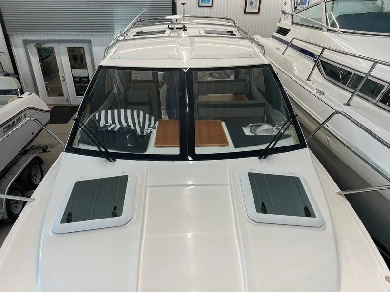 Slide: The Image of 2022 Cutwater C-24 Coupe boat in showroom, featuring sleek design and spacious cabin. - 24