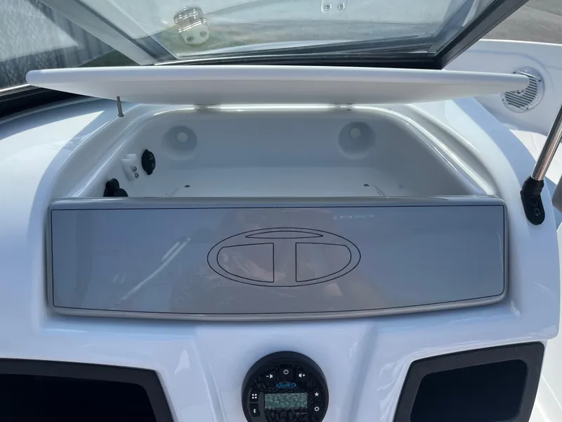 Slide: The Image of 2023 Tahoe 185 S boat dashboard with open storage compartment and control panel. - 13