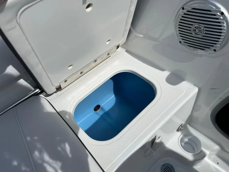 Slide: The Image of Open storage compartment in 2023 Tahoe 185 S boat, featuring a blue interior and speaker. - 15