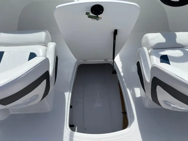 Slide: The Image of 2023 Tahoe 185 S boat interior storage compartment with open hatch and seating. - 18