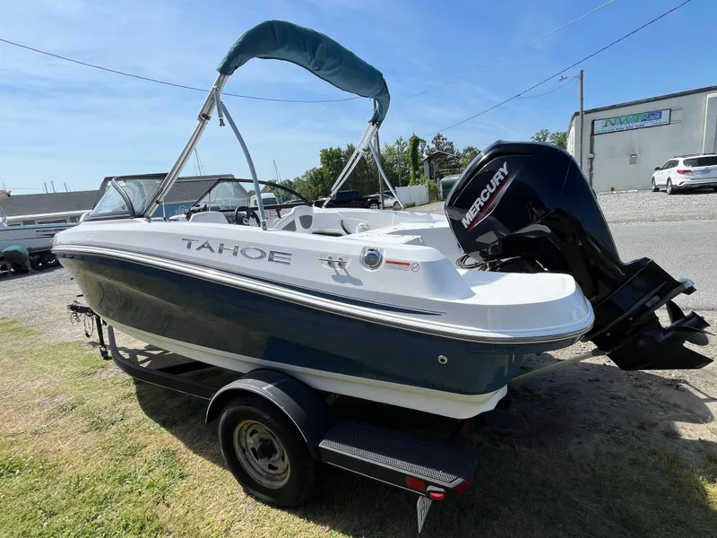 Slide: The Image of 2023 Tahoe 185 S boat with Mercury engine on trailer, parked outdoors. - 20