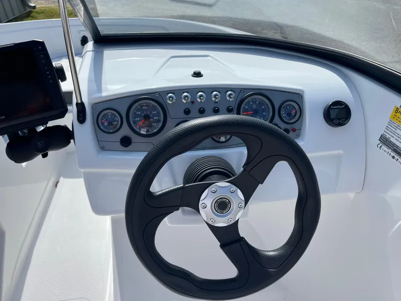 Slide: The Image of 2023 Tahoe 185 S boat dashboard with steering wheel and gauges. - 6