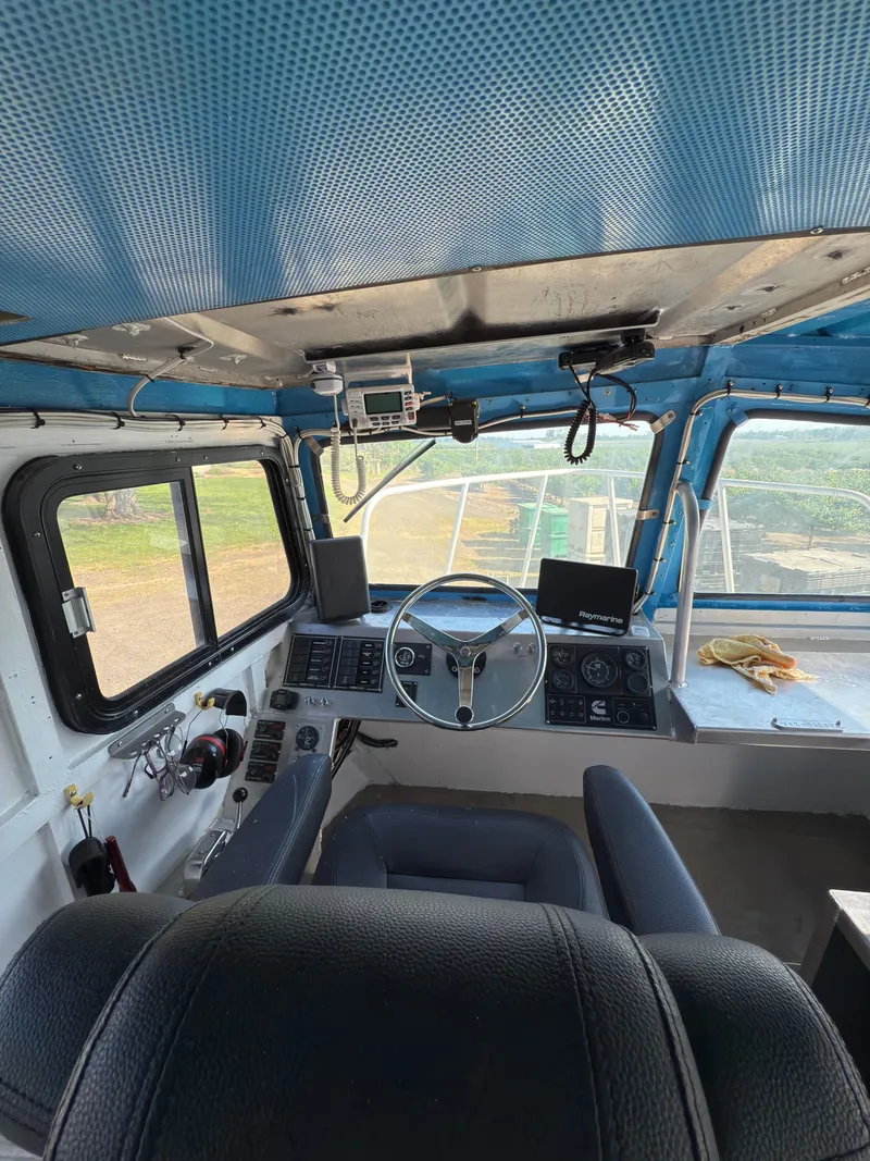 Slide: The Image of Interior of a 1975 Monark 30 Fishing Boat with steering wheel and control panel. - 13