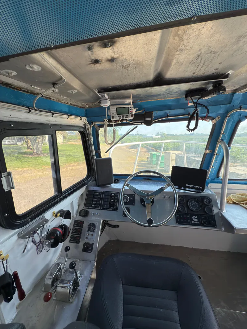 Slide: The Image of 1975 Monark 30 Fishing Boat cockpit with steering wheel, control panels, and navigation equipment. - 14