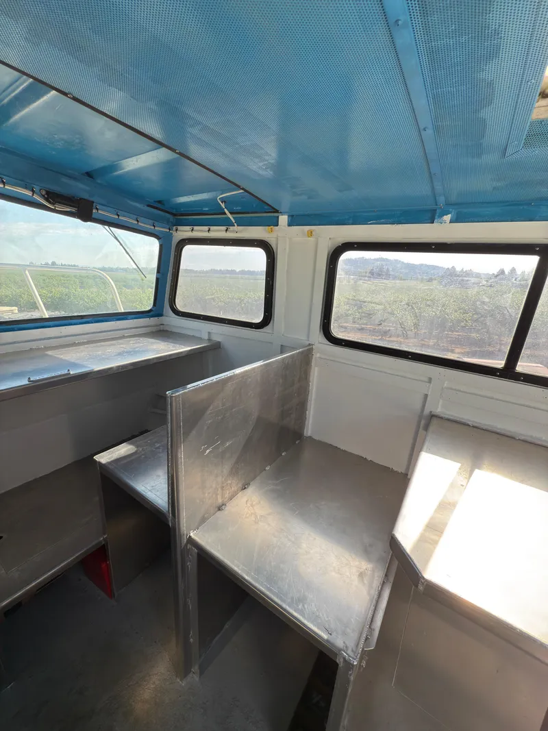 Slide: The Image of Interior of a 1975 Monark 30 Fishing Boat with blue ceiling and metal seating. - 21