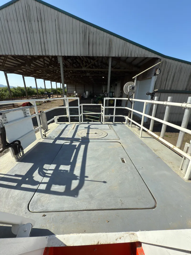 Slide: The Image of 1975 Monark 30 Fishing Boat deck with railing, docked near a wooden boathouse. - 25