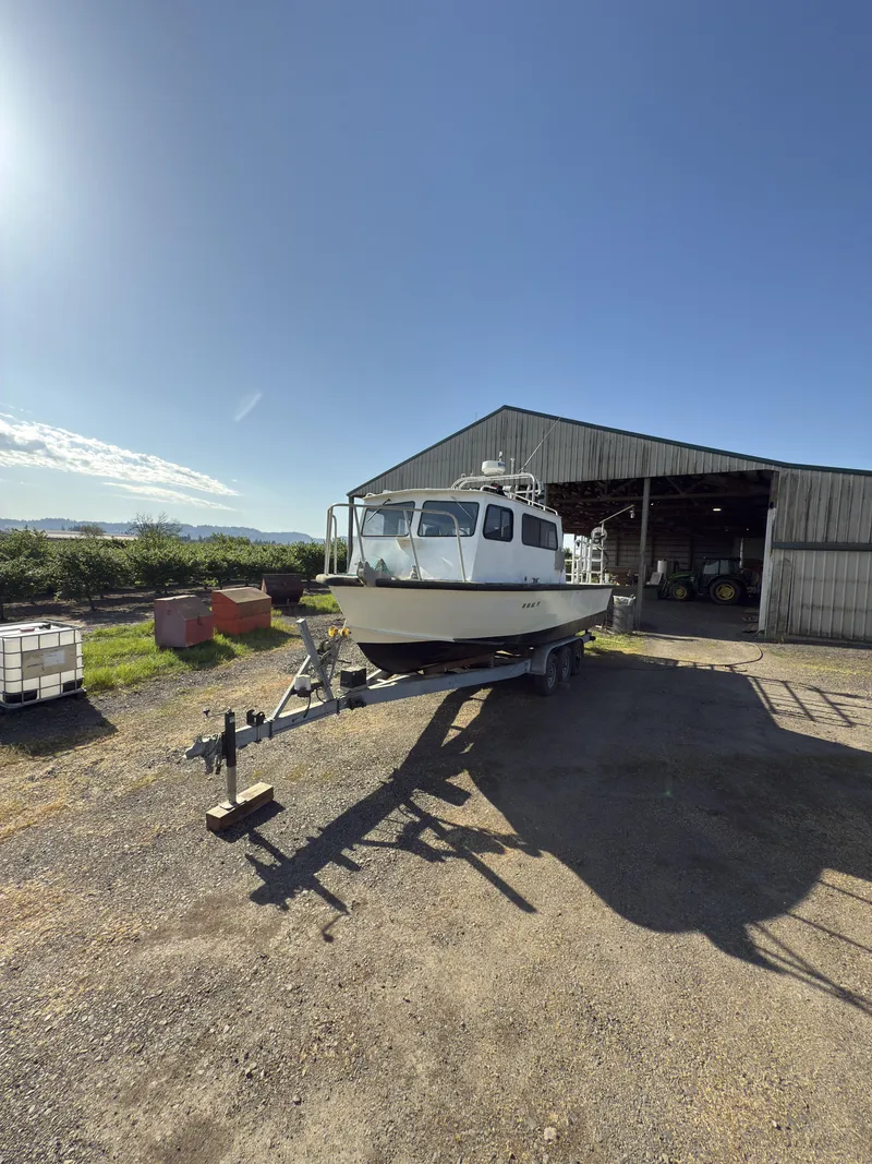 Slide: The Image of 1975 Monark 30 Fishing Boat on trailer near barn under clear blue sky. - 26