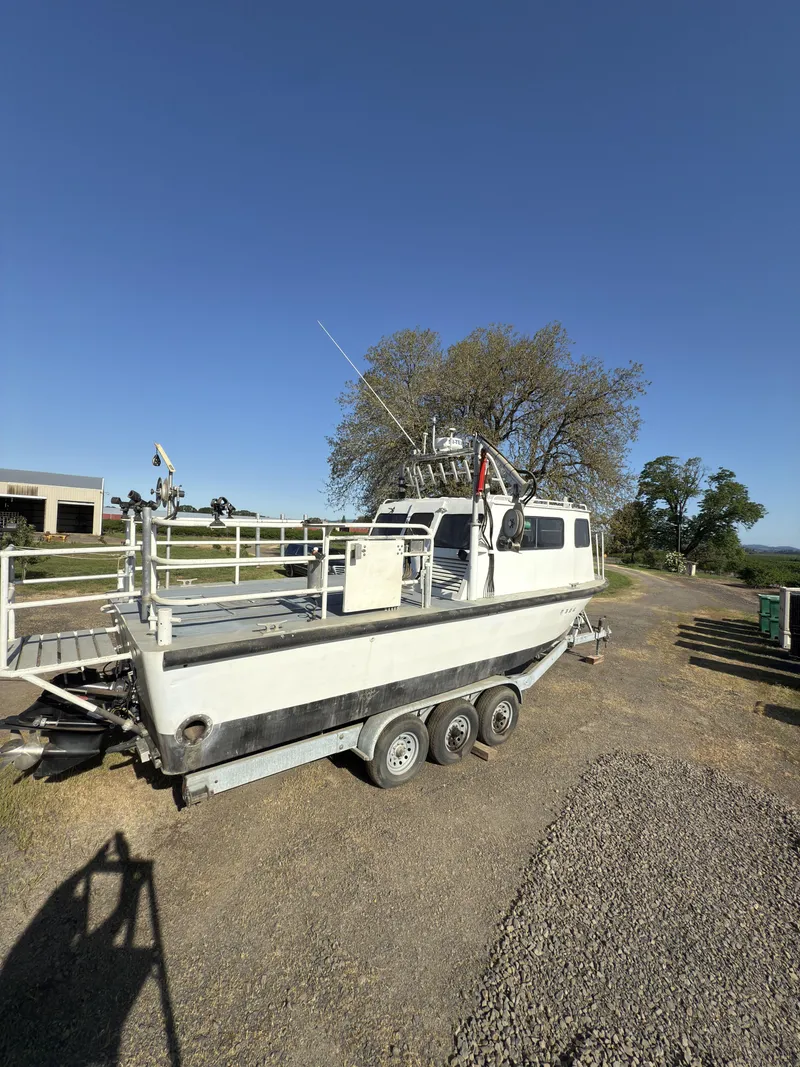 Slide: The Image of 1975 Monark 30 Fishing Boat on trailer, parked outdoors under clear blue sky. - 29