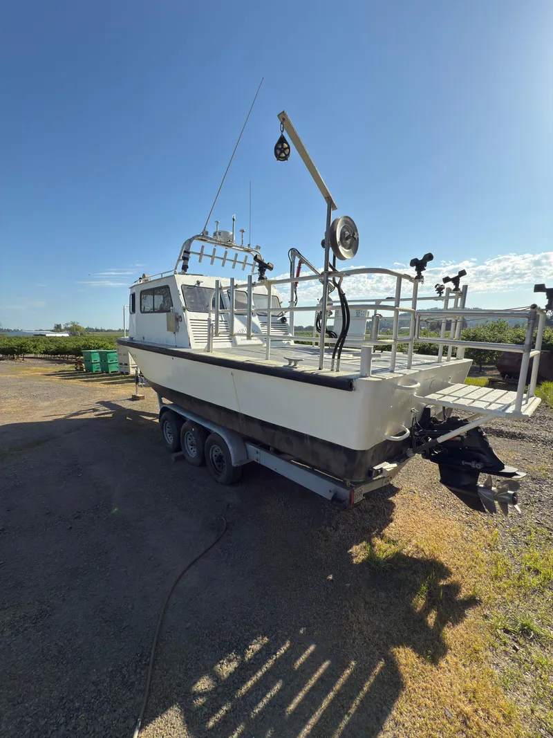 Slide: The Image of 1975 Monark 30 Fishing Boat on trailer, parked outdoors under clear blue sky. - 3