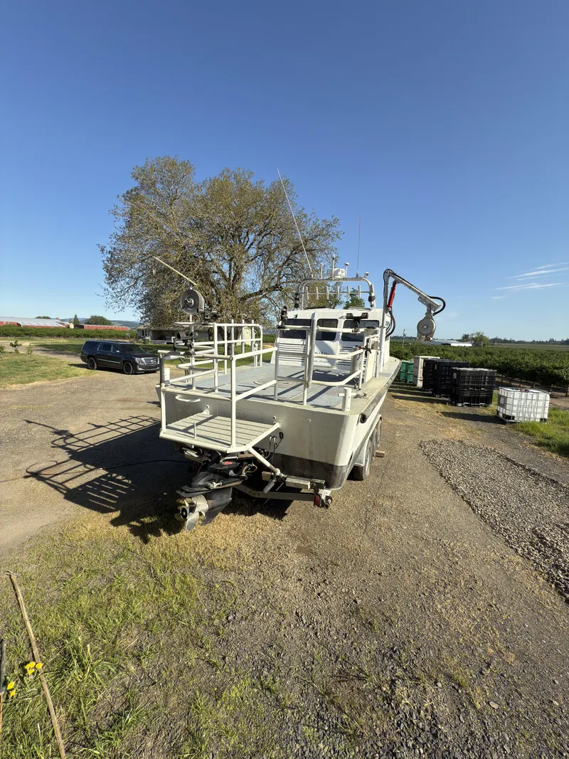 Slide: The Image of 1975 Monark 30 Fishing Boat on trailer, parked outdoors under clear blue sky. - 30