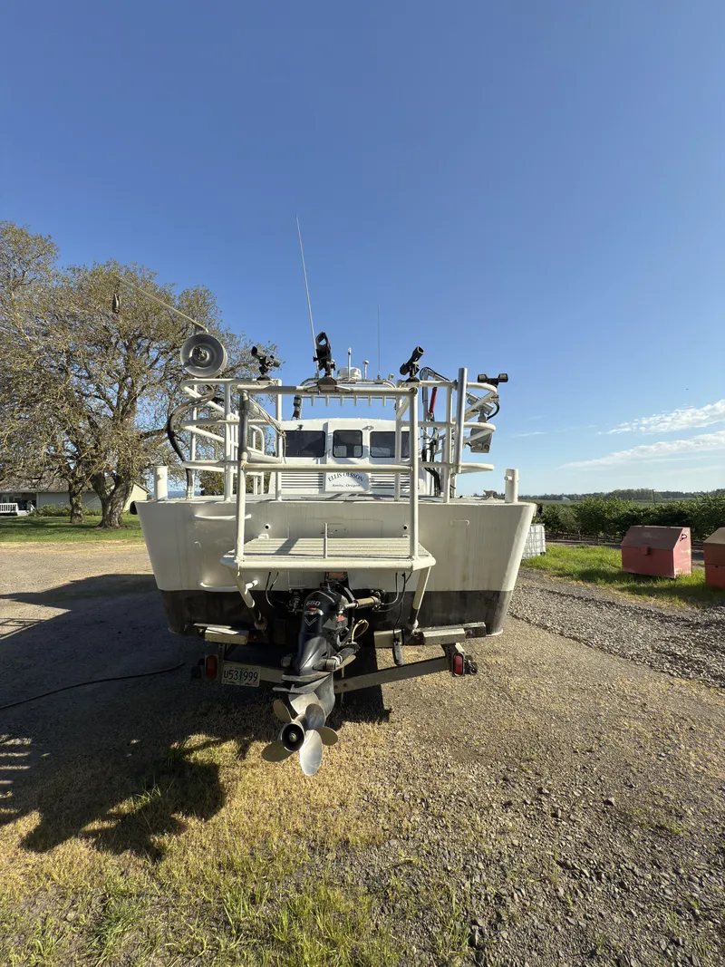Slide: The Image of 1975 Monark 30 Fishing Boat on trailer, parked outdoors under clear blue sky. - 33