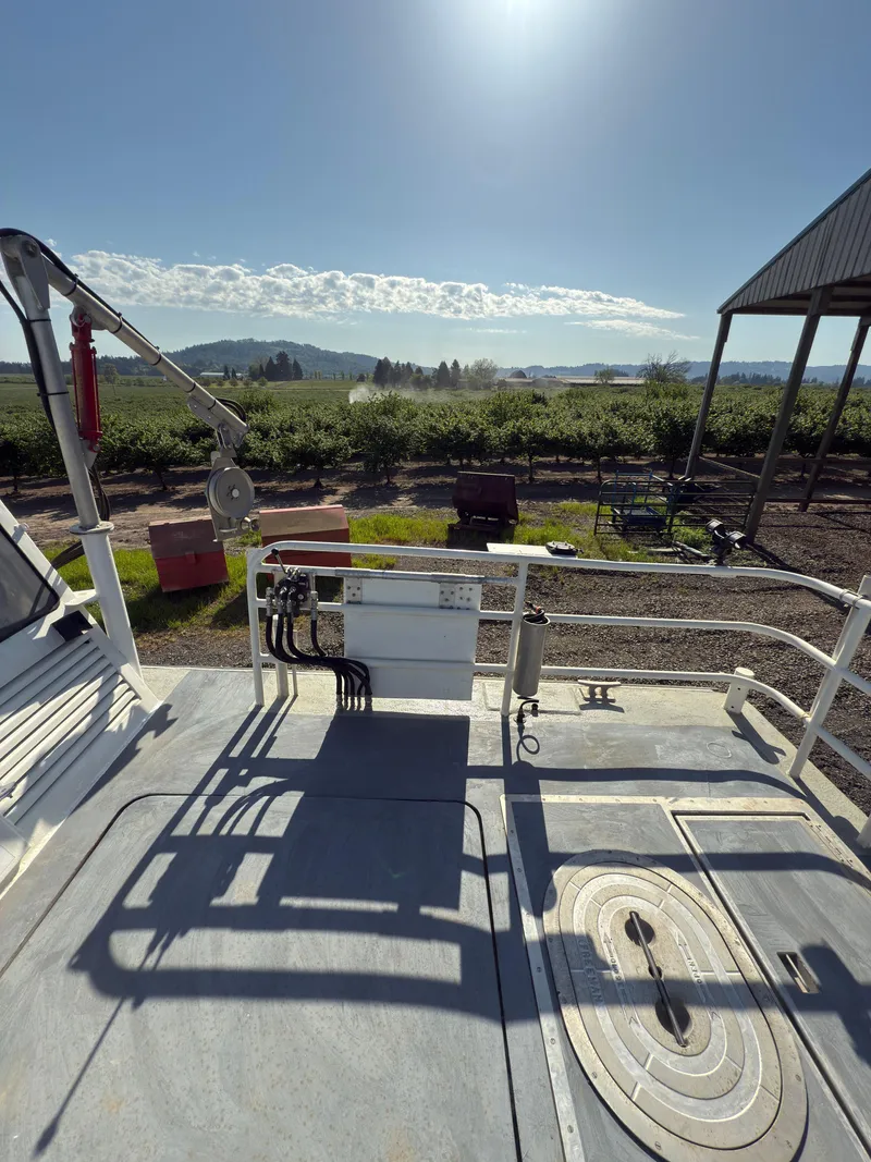 Slide: The Image of 1975 Monark 30 Fishing Boat deck with scenic countryside view under clear blue sky. - 7