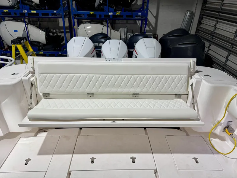 Slide: The Image of 2020 Intrepid 407 Nomad FE boat with white cushioned seating and outboard motors in background. - 14