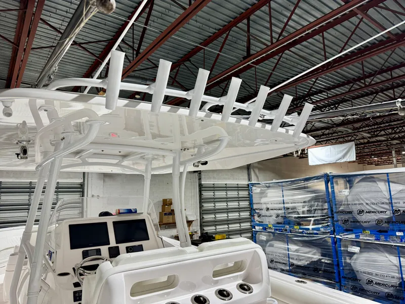 Slide: The Image of 2020 Intrepid 407 Nomad FE boat interior with rod holders and control panel in a warehouse. - 19