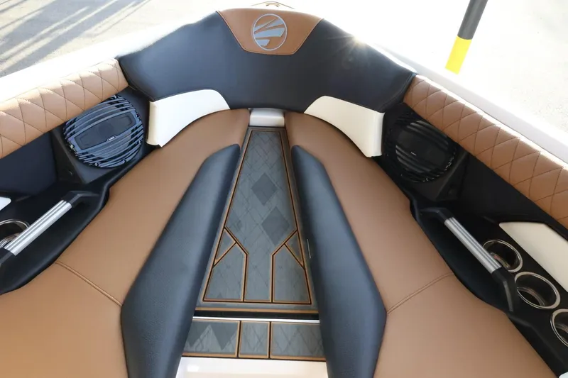 Slide: The Image of 2025 Tigé Z3 boat interior with brown and black seating, cup holders, and speakers. - 21