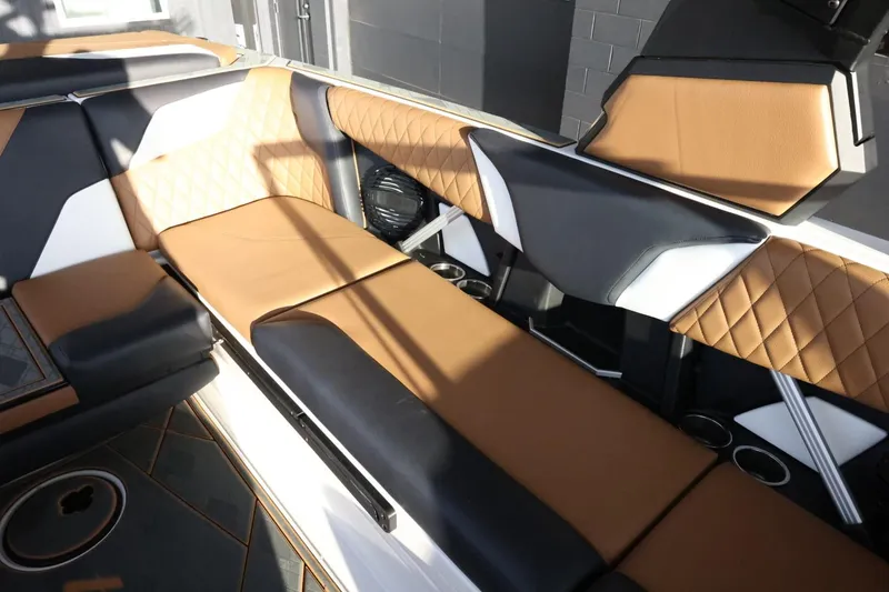 Slide: The Image of 2025 Tigé Z3 boat interior with luxurious tan and black seating, quilted design, and cup holders. - 30
