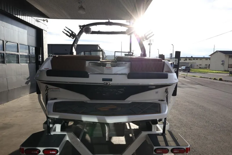 Slide: The Image of 2025 Tigé Z3 boat on trailer, rear view, in sunlight at a marina. - 8