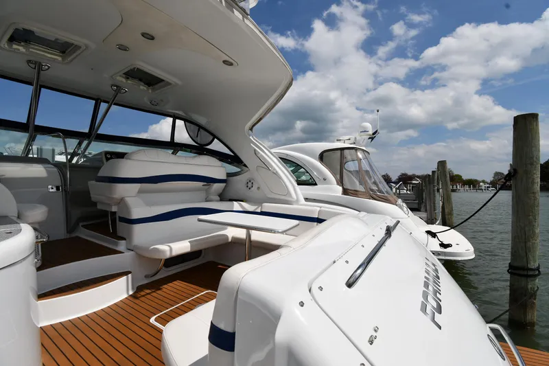 Slide: The Image of 2009 Formula 40 PC yacht docked, featuring sleek design and spacious deck under a partly cloudy sky. - 21
