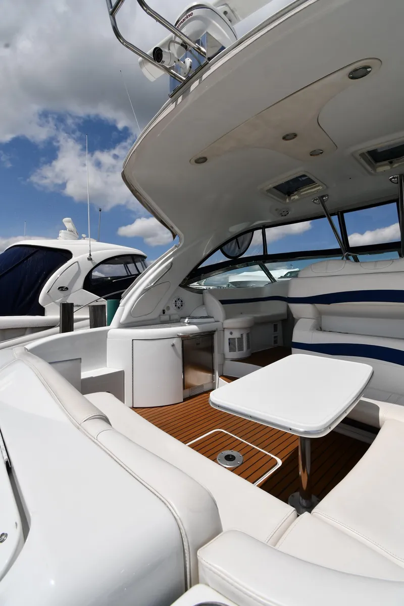 Slide: The Image of 2009 Formula 40 PC yacht interior with white seating and wooden flooring under a blue sky. - 24