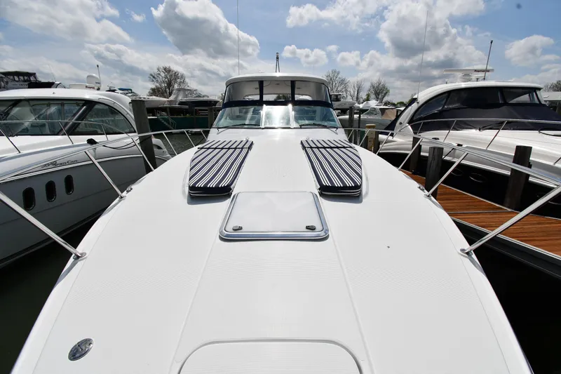 Slide: The Image of 2009 Formula 40 PC yacht docked, showcasing sleek design and spacious deck under a cloudy sky. - 3