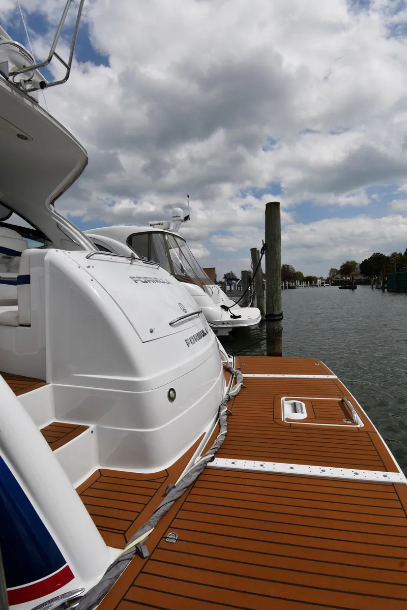 Slide: The Image of 2009 Formula 40 PC yacht docked, showcasing sleek design and wooden deck under cloudy skies. - 8