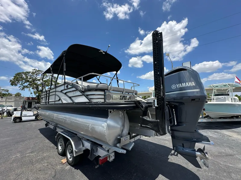 Slide: The Image of 2021 Bennington LX 24 Stern Lounge pontoon boat with Yamaha engine on trailer. - 1