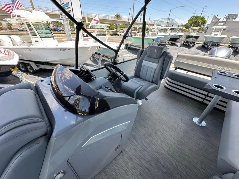Slide: The Image of 2021 Bennington LX 24 Stern Lounge interior with sleek seating and modern dashboard. - 15