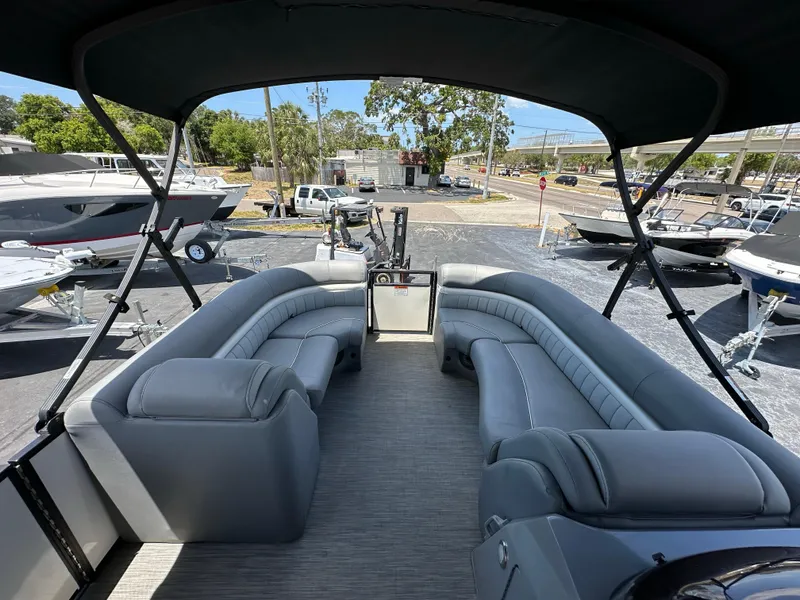 Slide: The Image of 2021 Bennington LX 24 Stern Lounge with spacious seating and canopy, parked in a marina. - 17