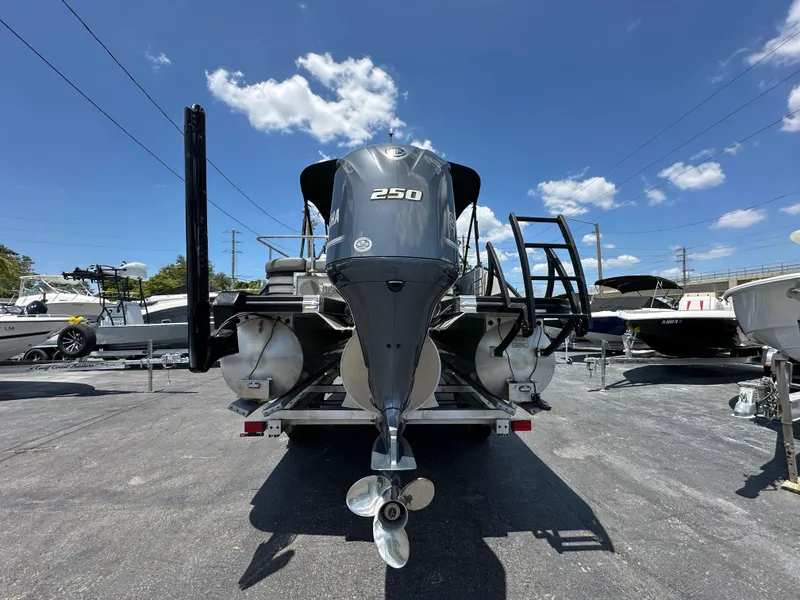 Slide: The Image of 2021 Bennington LX 24 Stern Lounge boat with powerful 250 engine, parked outdoors. - 2